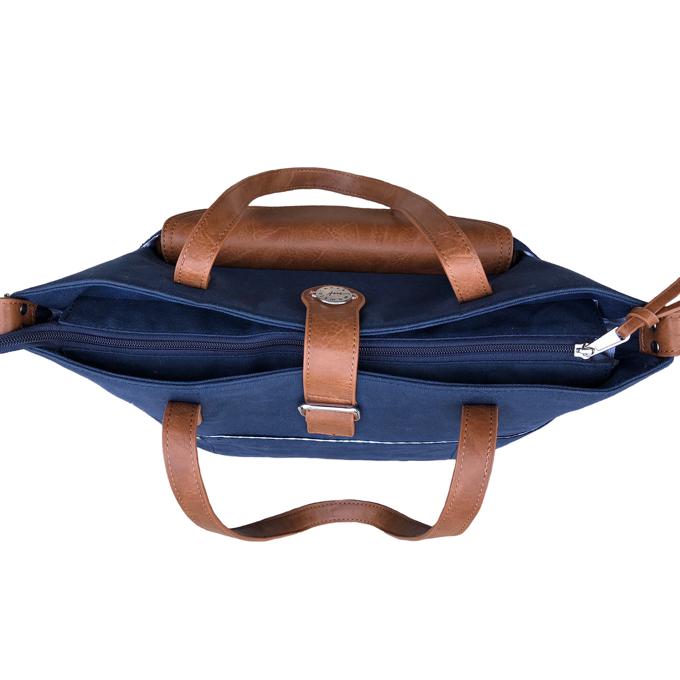 Top down view of navy waxed canvas CarryAll Tote with caramel brown vegan leather accents, zip closed on white background.
