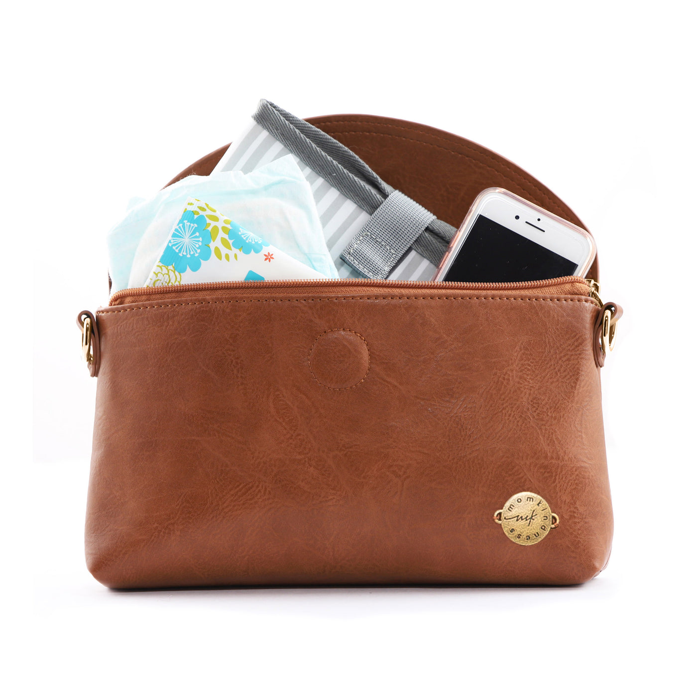 A caramel brown vegan leather clutch bag, unzipped with flap open and showing cell phone, diaper, wipes case and changing mat inside, all on a white background.