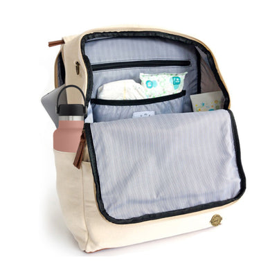 A front-facing 3/4 view of a stone colored waxed canvas backpack with front flap zipped open showing pockets inside, a water bottle in side pocket, and a laptop in separate back compartment. Wipe-clean lining is a thin black and white stripe pattern with black accents. Image shown on a white background.