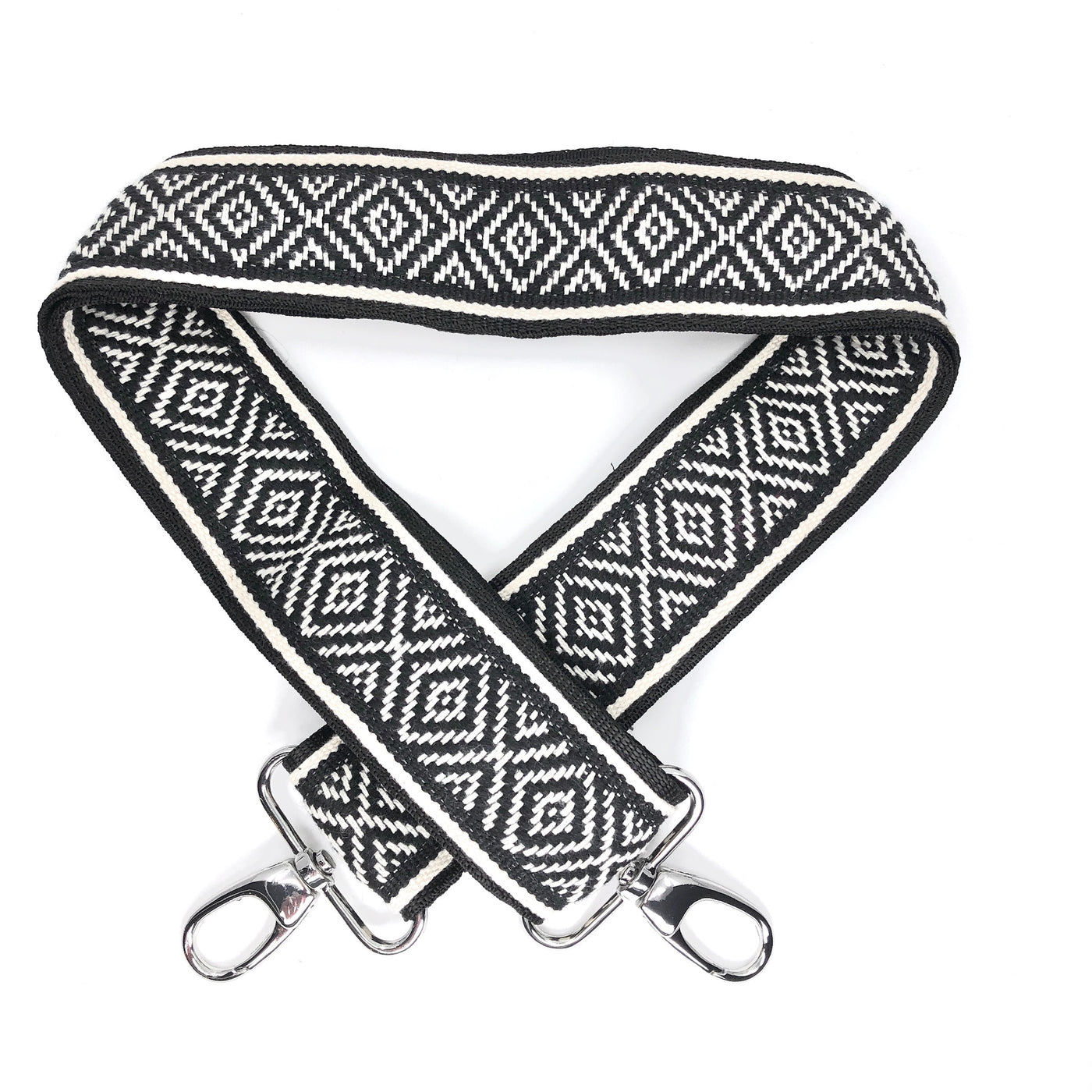 A black and white diamond patterned woven messenger strap with sliver-colored buckles, shown laying on a plain white background.