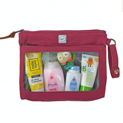 A berry colored canvas pouch with 2 zip-close compartments, a clear view window showing baby care items and a wristlet strap, on a white background.