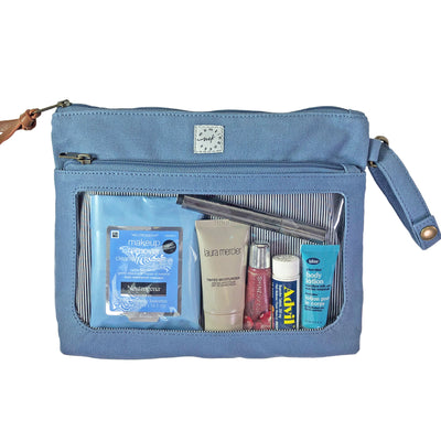 A dusty blue colored canvas pouch with 2 zip-close compartments, a clear view window showing cosmetic items and a wristlet strap, on a white background.