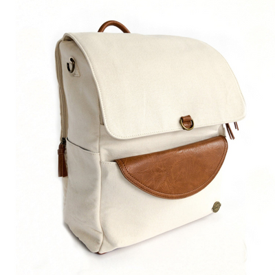 Front-facing 3/4 view of large capacity stone colored canvas backpack with brown vegan leather accents and removable clutch. Side pocket and separate zip-top laptop pocket on back of pack can be seen as well as top carry handle. Image shown on white background.