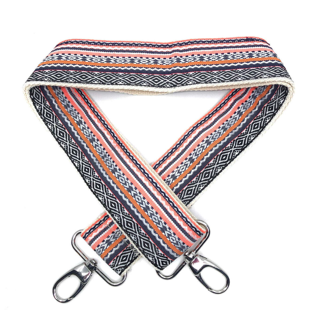 A close-up on white background of an adjustable length, woven bag strap with black, white, orange and pink pattern and metal clasp. 